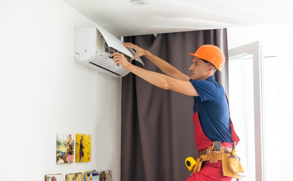 Technician repairing air conditioner on the wall